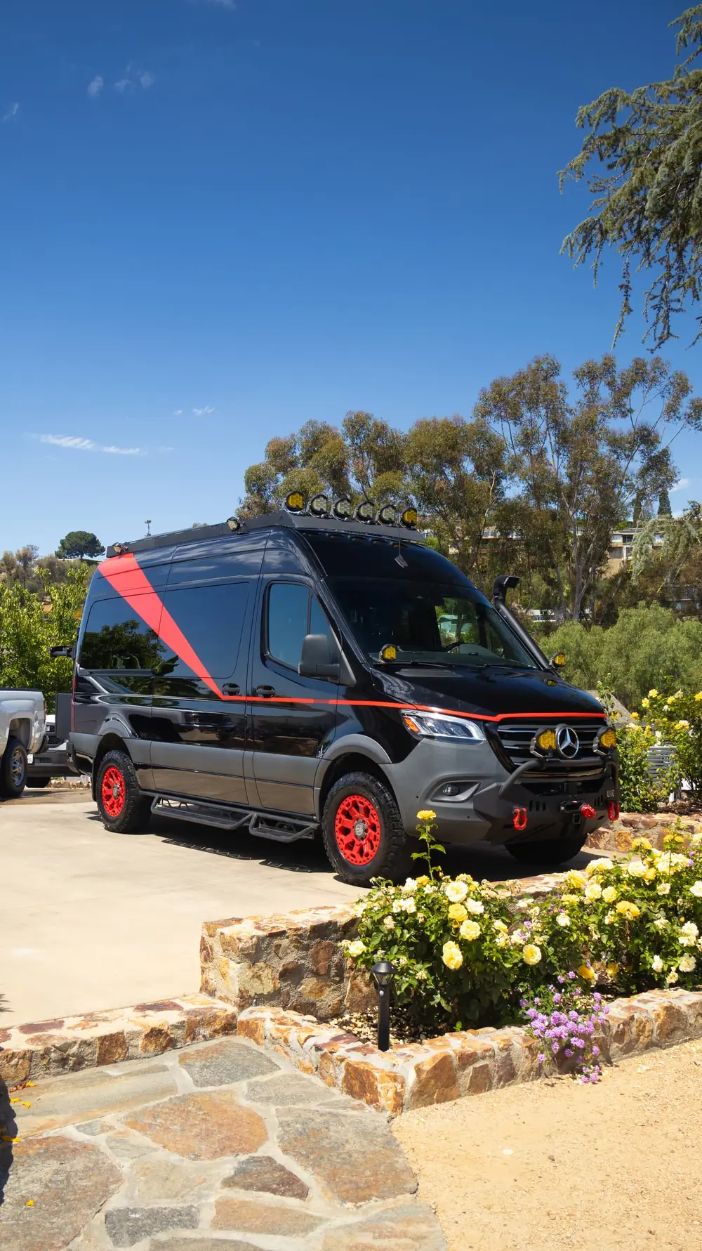 Alpine paint correction: black and red off-road Sprinter van parked in a driveway