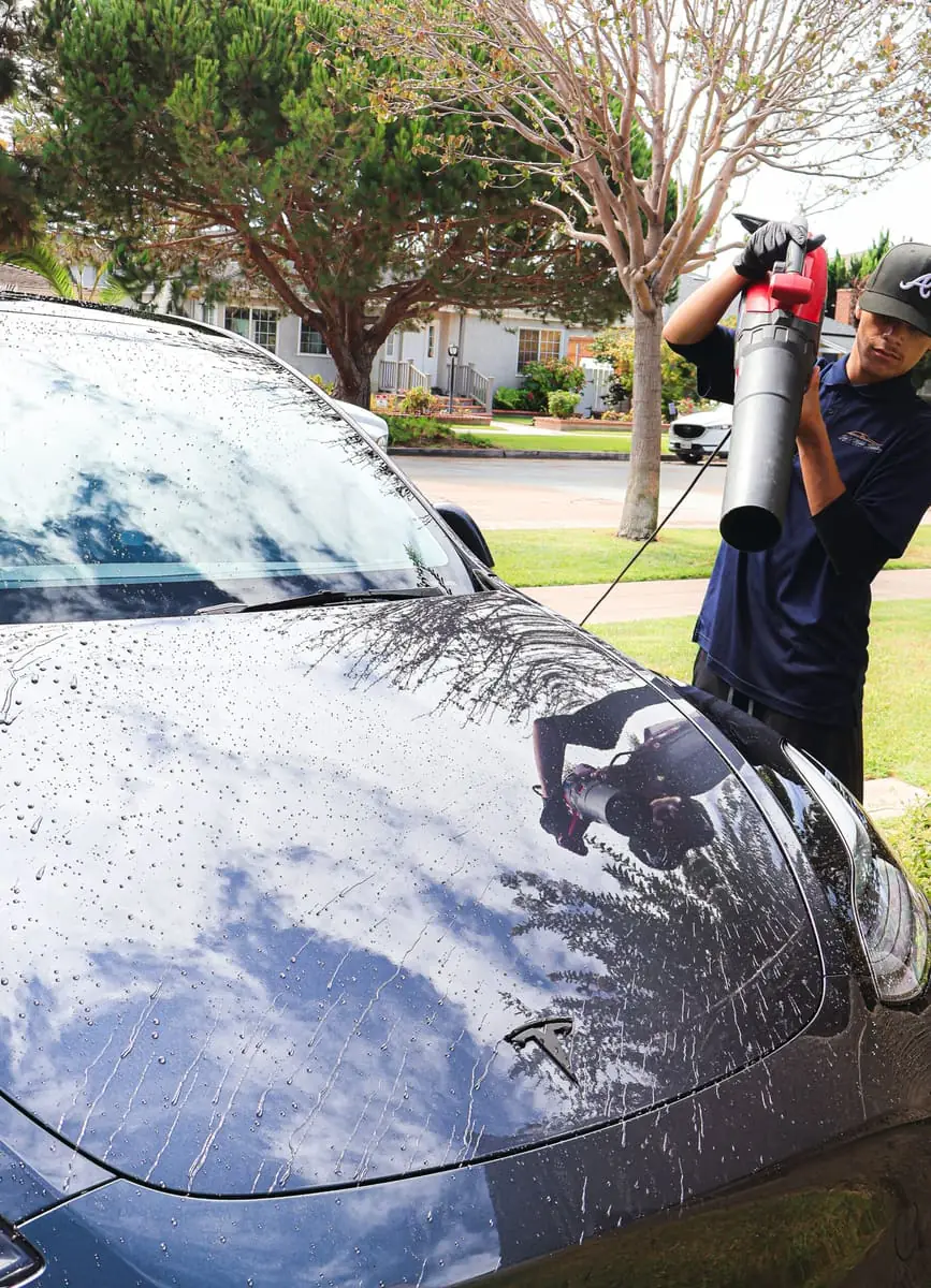 Rancho San Diego paint correction: technician air-drying a gray Tesla with a blower