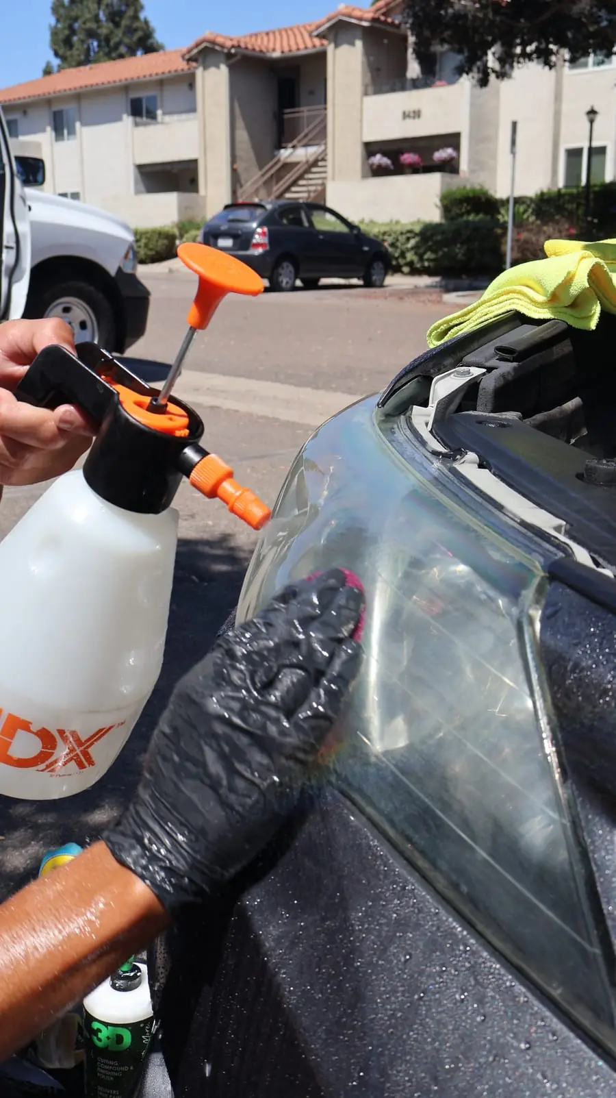 Spring Valley paint correction: technician spraying and wiping a hazy headlight